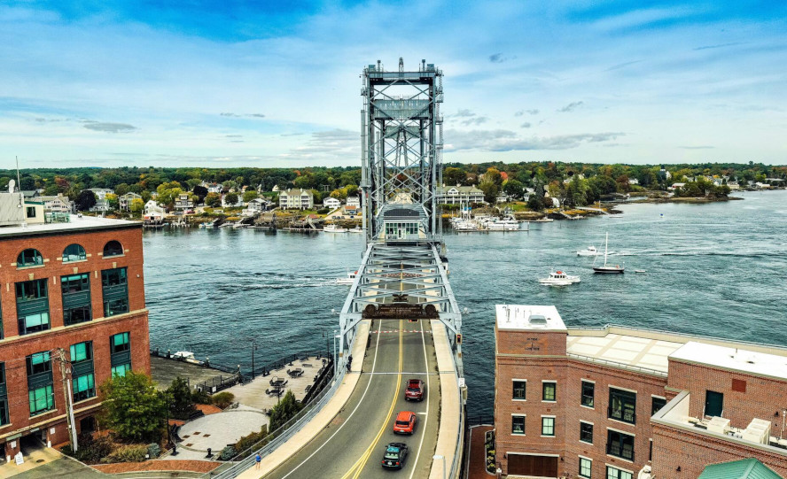A bridge spans over water, with several cars traveling across its surface